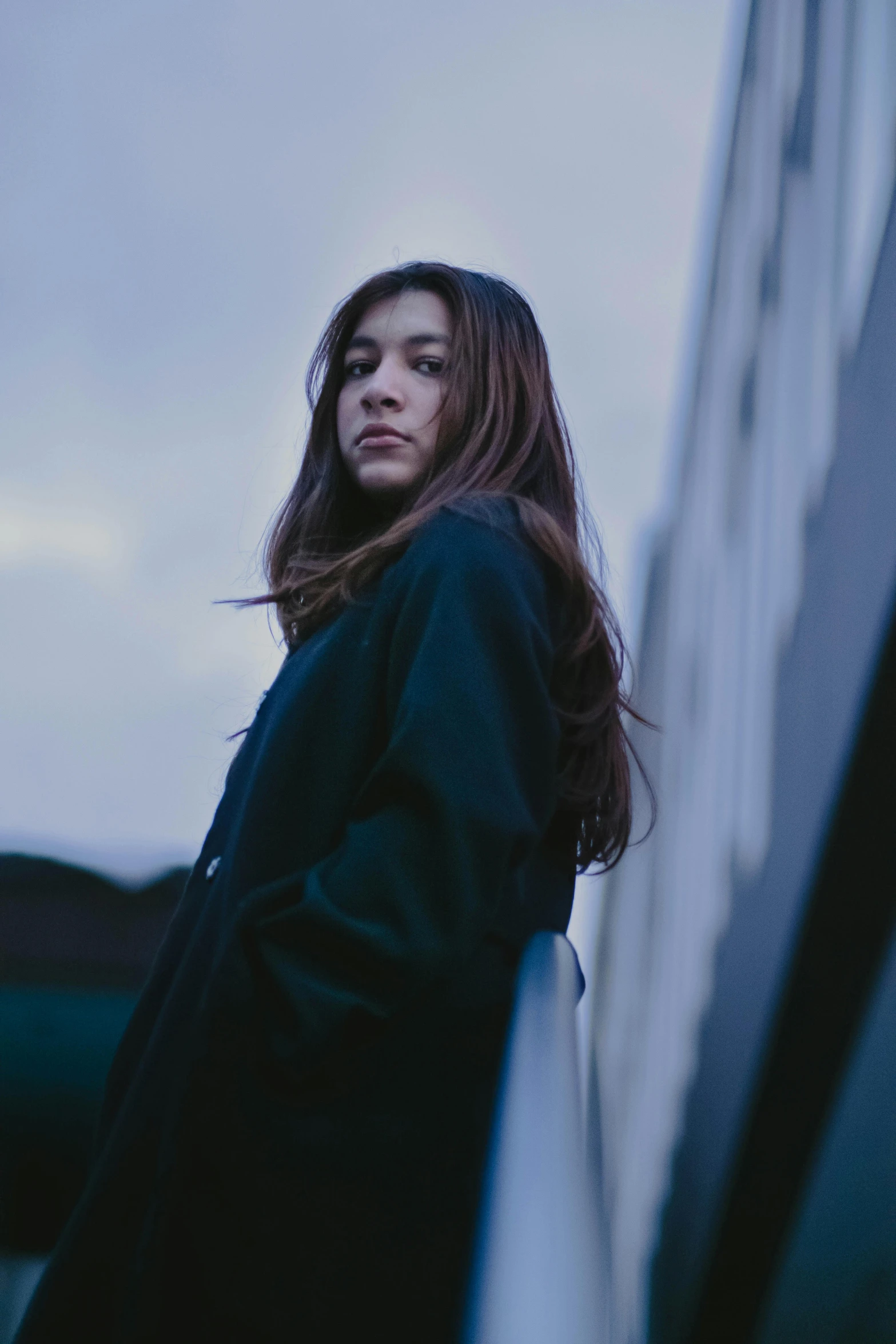 a woman is leaning against the side of a building