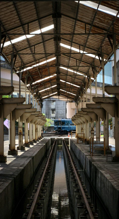 an empty train station with one train passing through it