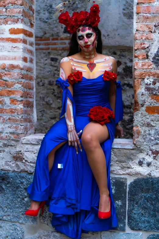 a woman in a costume sitting on a ledge