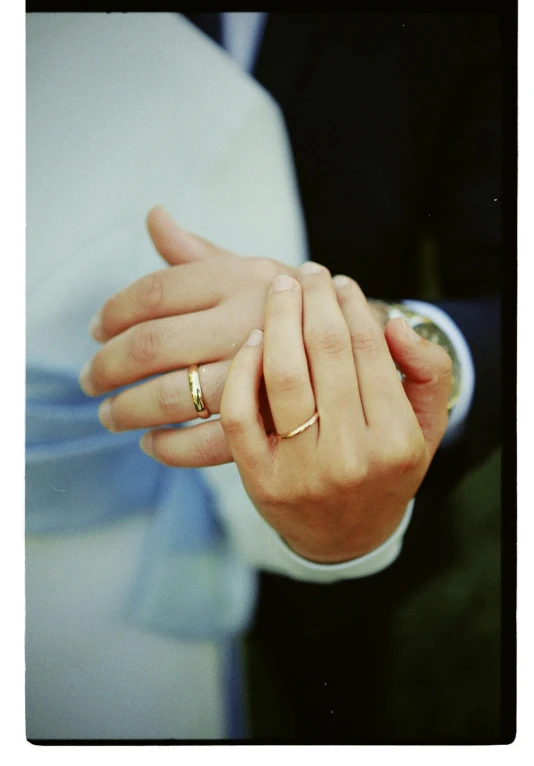 a couple in matching rings hold hands together