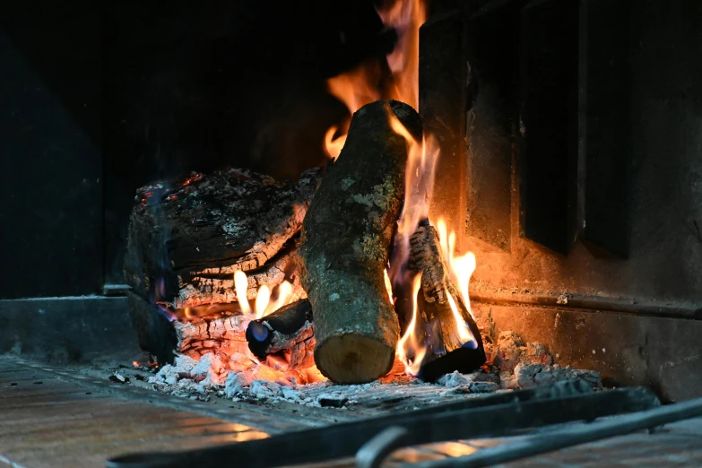 a fire burning inside of a fireplace with flames