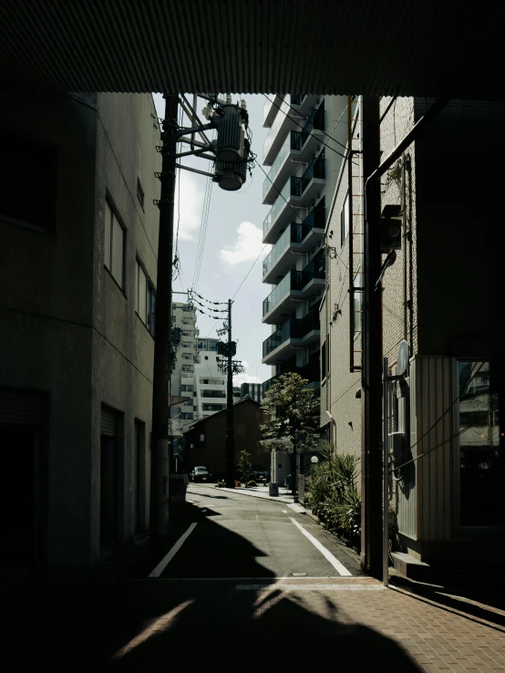 the shadows are cast on the pavement in an alley way