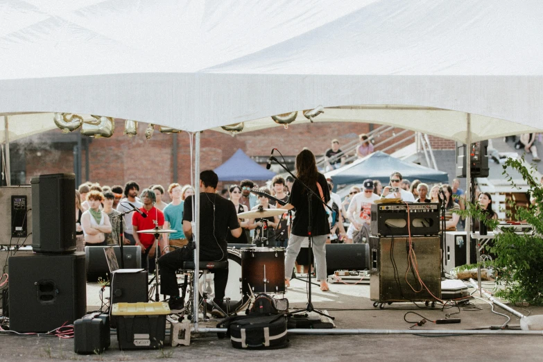 two people standing on stage with lots of instruments in front of a crowd