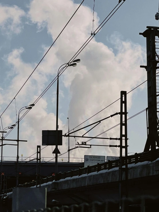 train driving over a bridge next to many power lines