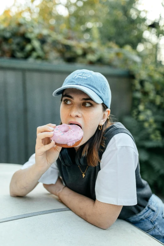 a woman with a hat eating a doughnut