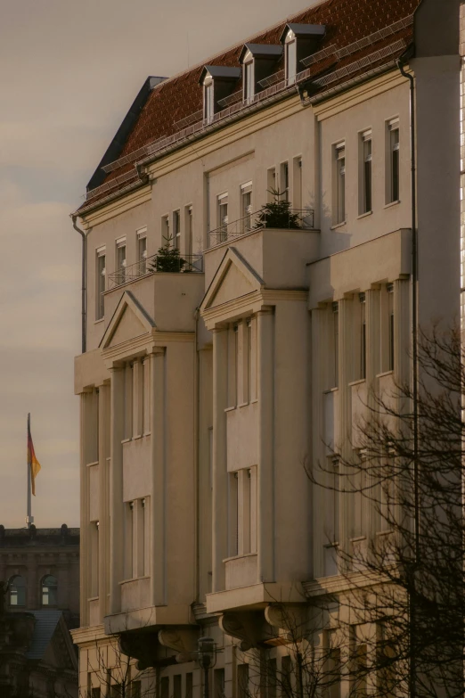 a large white building with two flags flying in the background