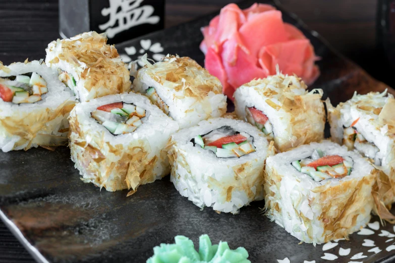 four pieces of sushi placed on a black plate