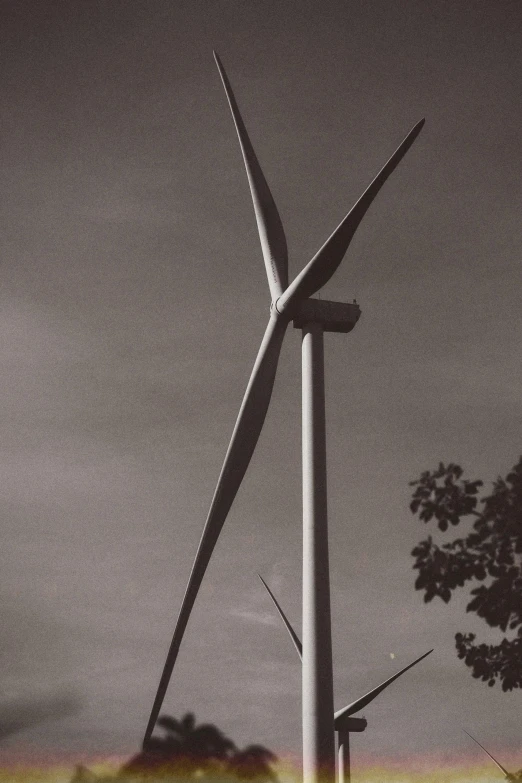 black and white pograph of wind turbines against dark cloudy sky