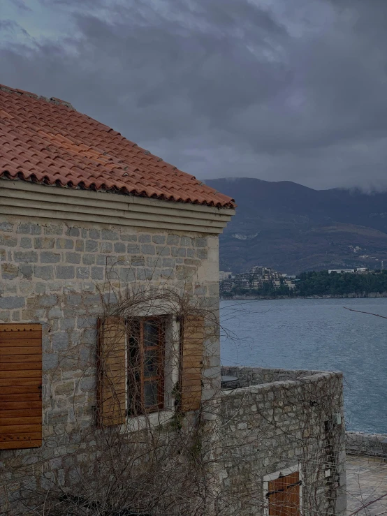 a building next to a body of water under a cloudy sky