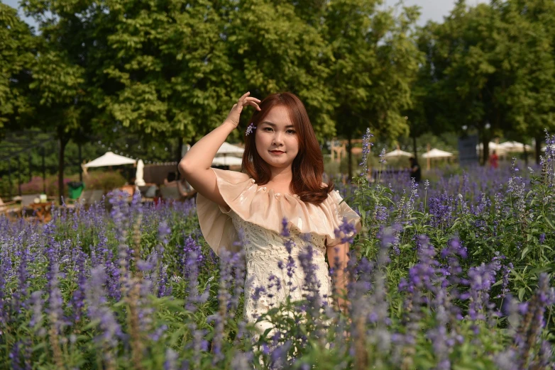 a woman standing in a field of purple flowers