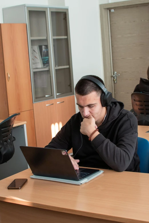 a man that is sitting in front of a laptop computer