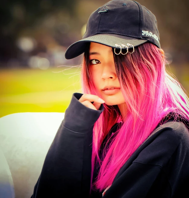 a girl with pink hair wearing a baseball hat