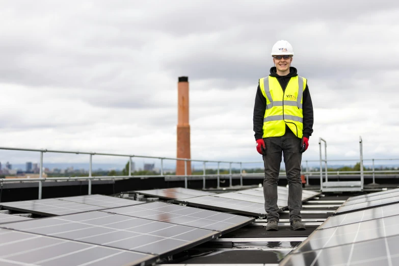 a man in safety vest standing on solar panels