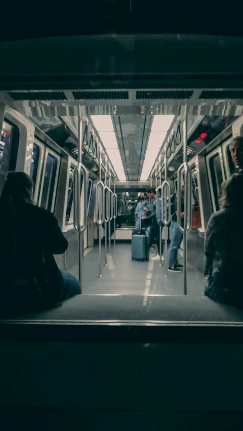 people sitting and standing in an empty subway car