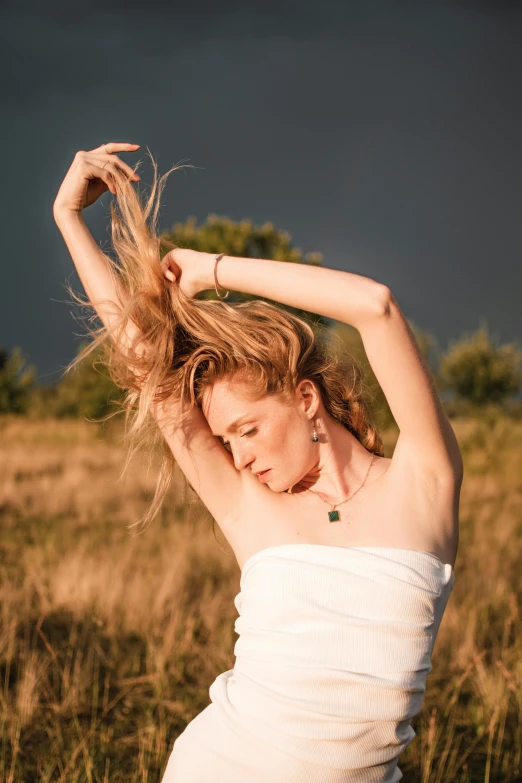 a woman wearing a white dress in a field