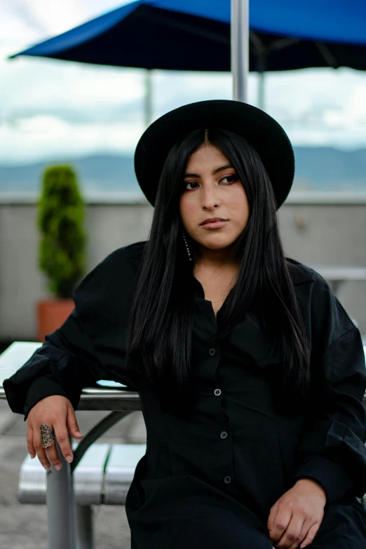 a woman with a hat sitting on a bench