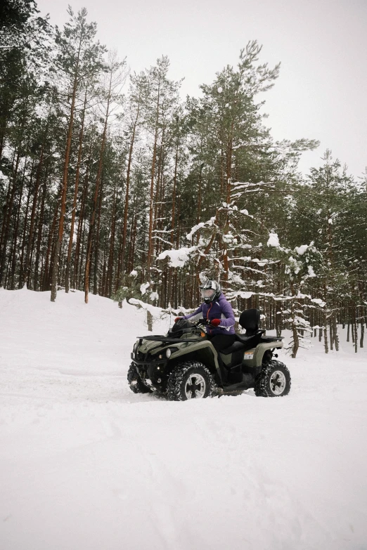 two people riding a four - wheeler in the snow