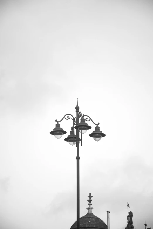 the street light has four lanterns attached to it