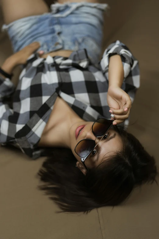 a young woman lying on the floor wearing sunglasses