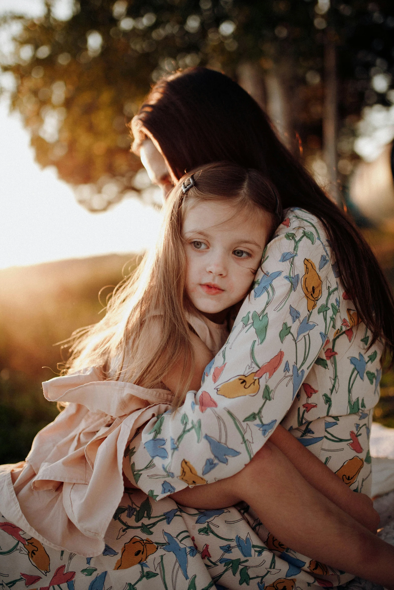 a girl is sitting with her arms around her face