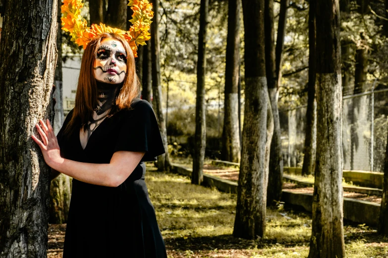 woman with face painted as a devil standing in forest