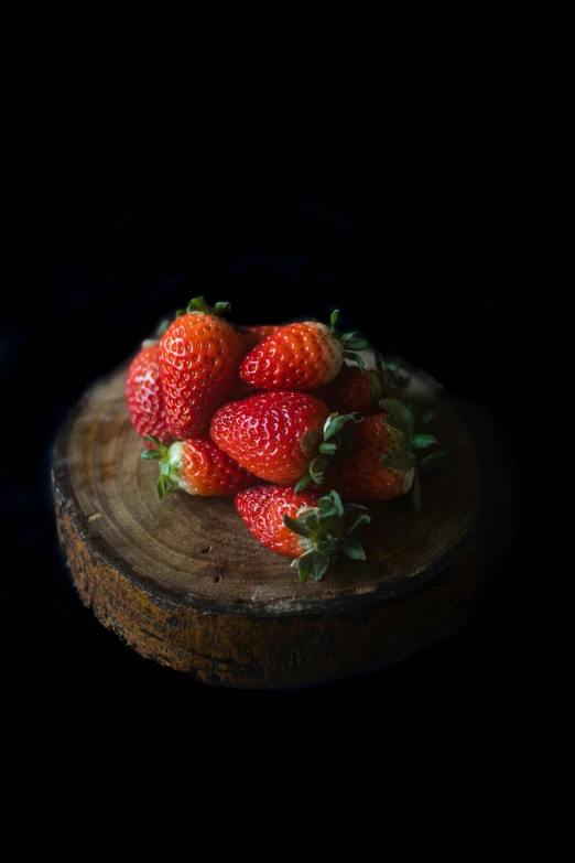 a close up view of several strawberries on the top of a round board