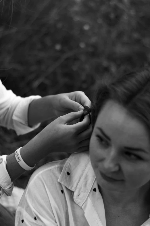  getting her hair done while mother puts on a celet