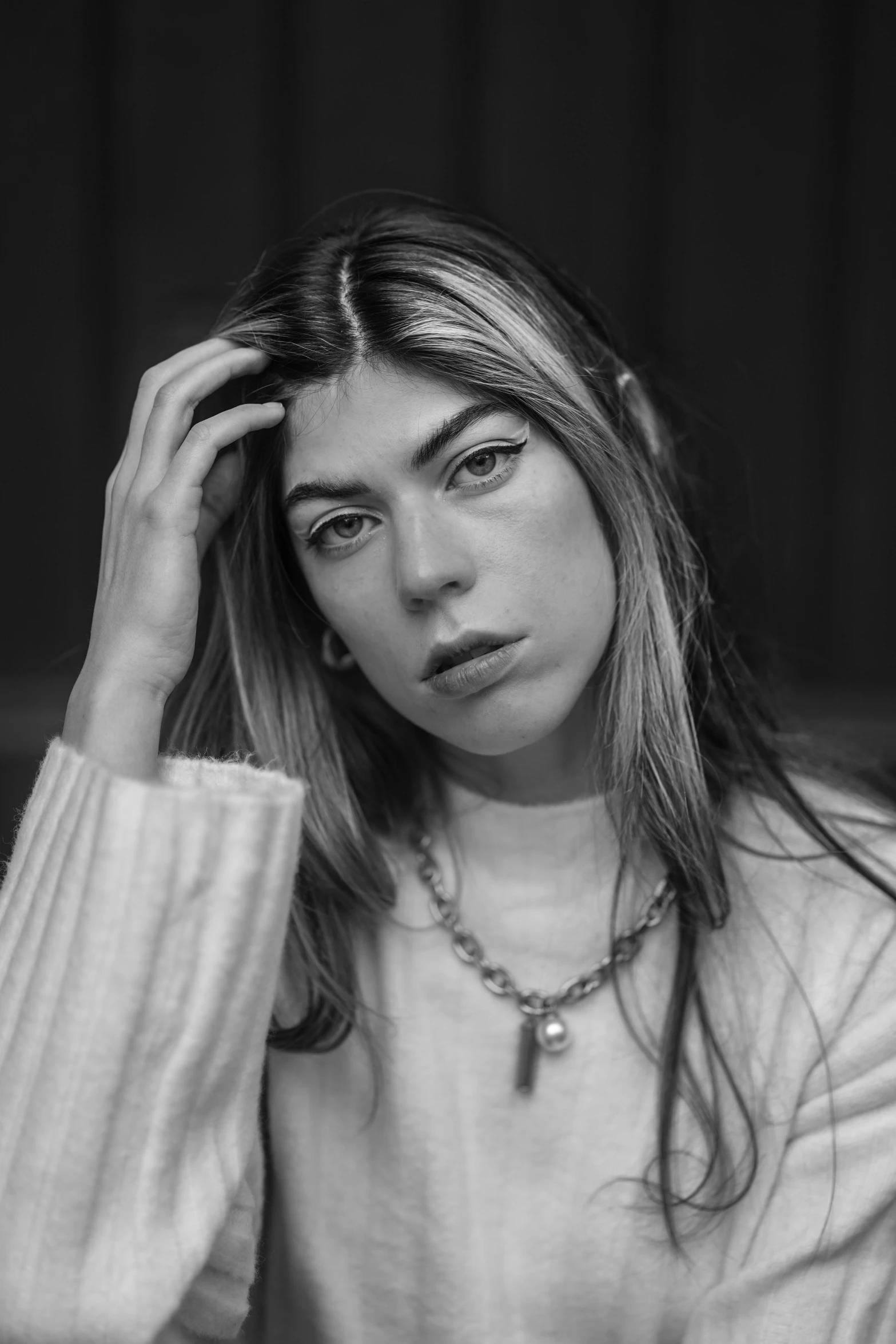 woman posing for black and white image holding her head