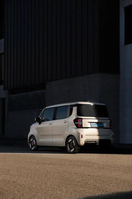 a white minivan is parked in front of an industrial building