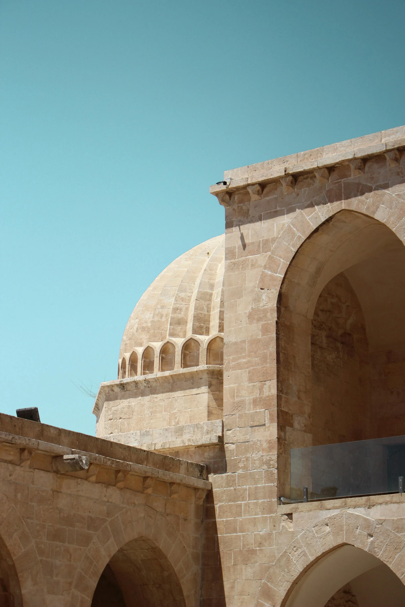 a bird perches on top of the building near arches