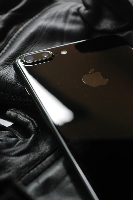 an iphone on top of some black leather