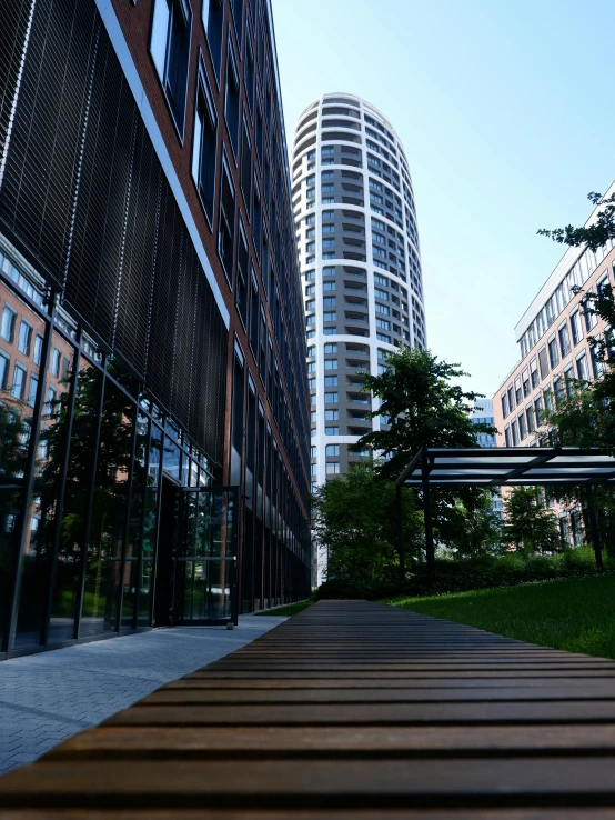 there is a wooden walkway next to tall buildings