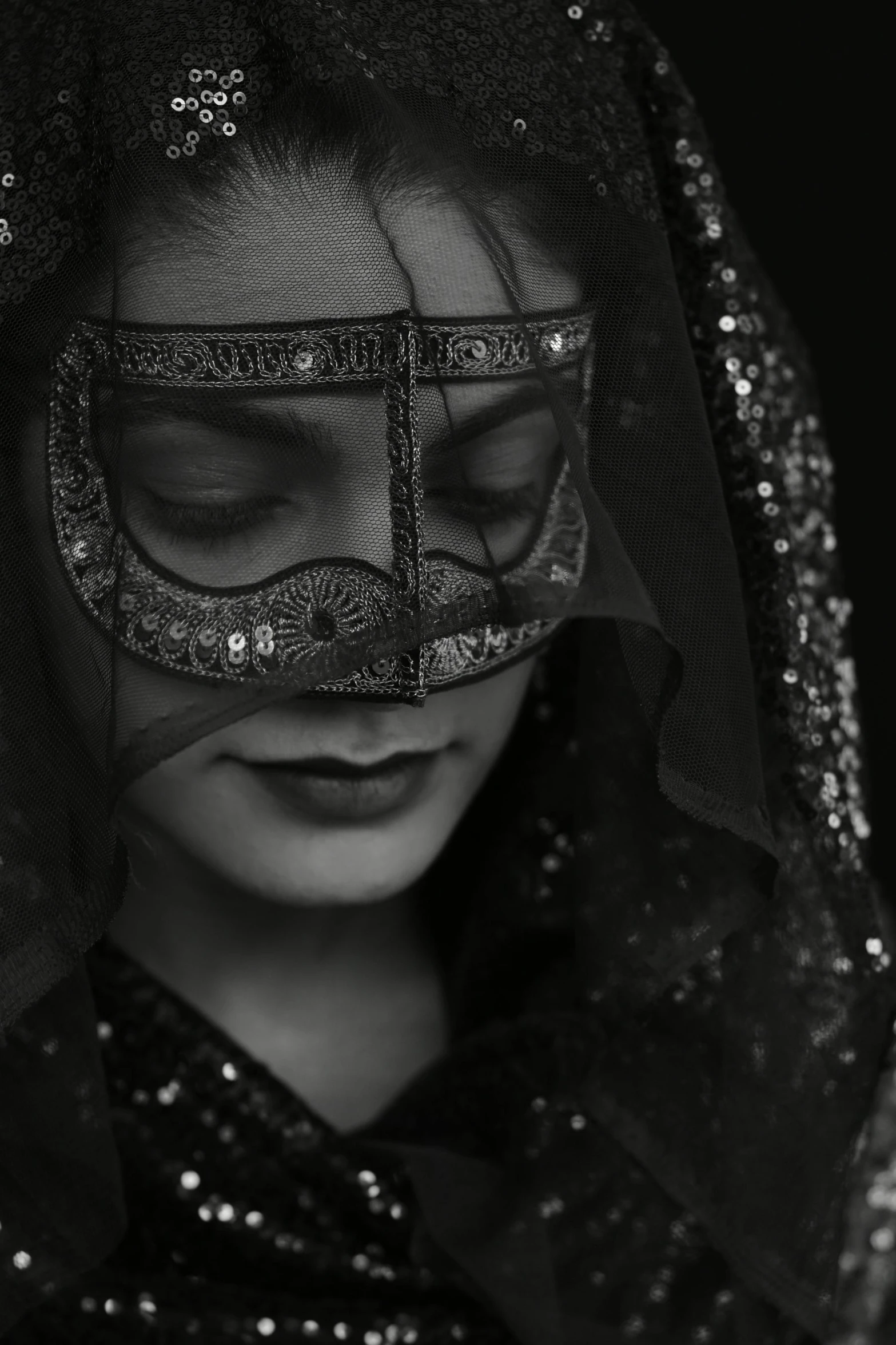 a beautiful young lady wearing a veil with sequins on it