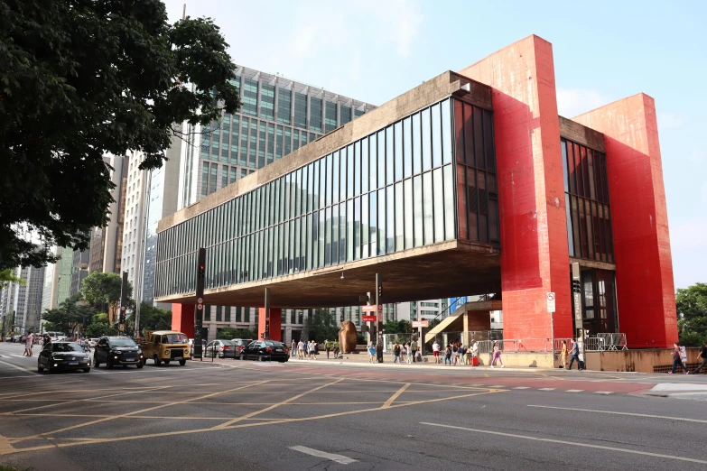 the modern building is red and grey with a large glass entrance