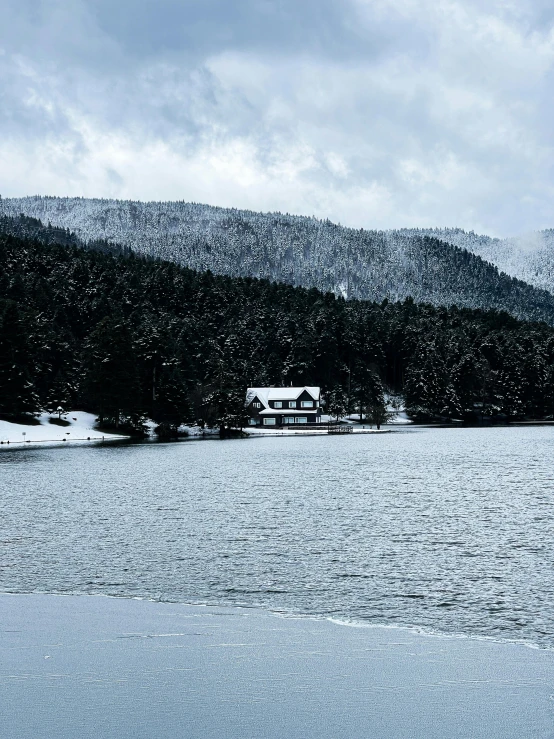 a po of a snow covered lake with a building in the distance