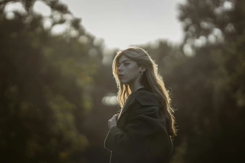 a person stands in a forest and stares off into the distance