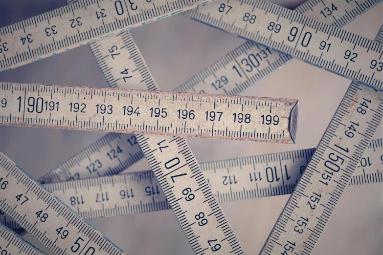 a close up of many plastic rulers pointing to different heights