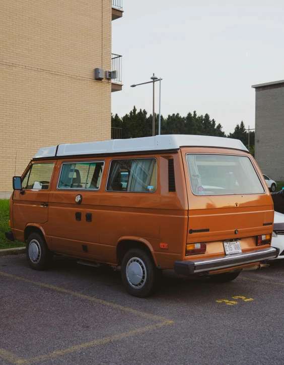 an orange van sitting in a parking lot