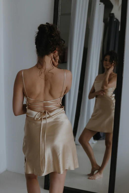 a woman looking in a mirror while standing up