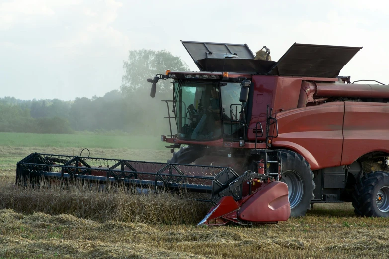 a big red truck is next to a large farm machine