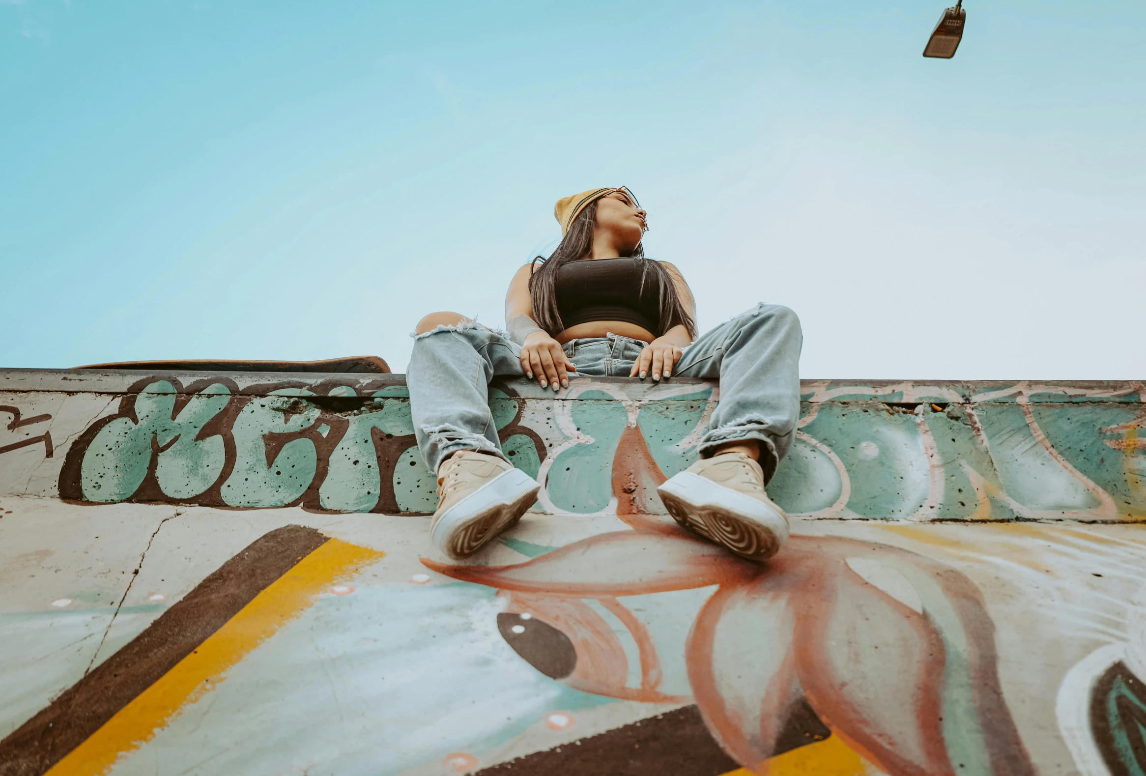 man sitting on the side of a large skateboard ramp