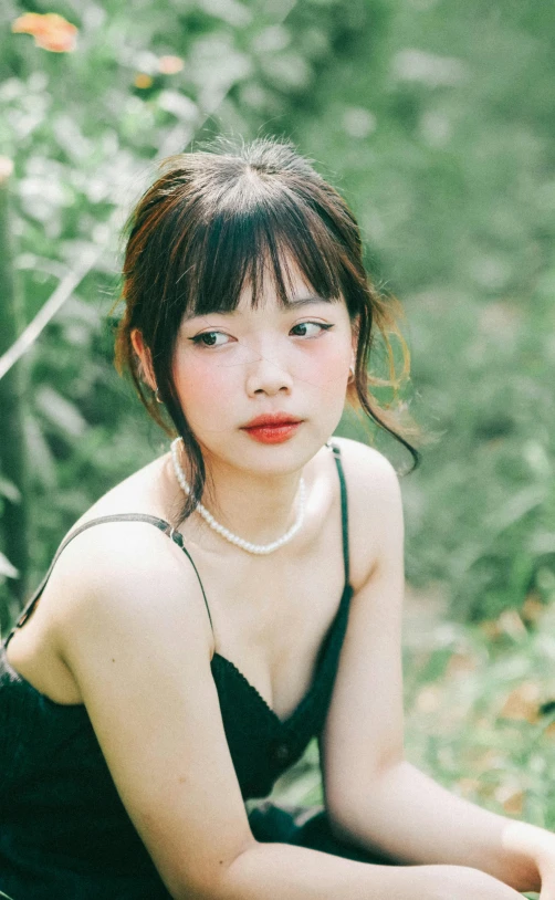 young woman posing in the forest with a necklace