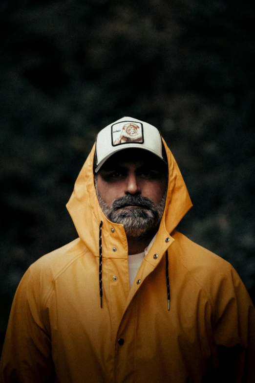 a man wearing yellow and white hat under his hood