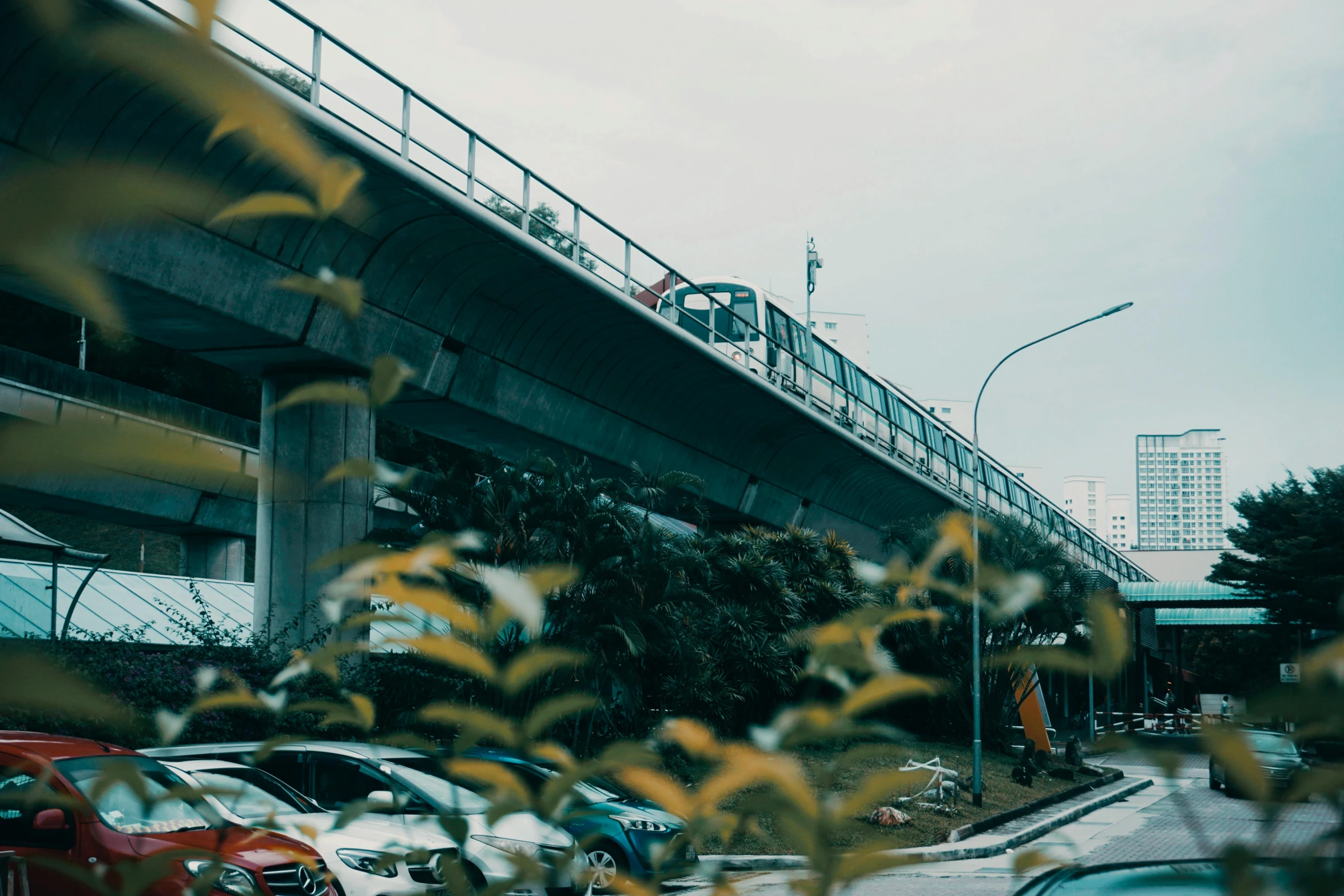 a red car is parked underneath a green bridge