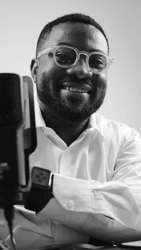 a man in glasses is leaning on a table