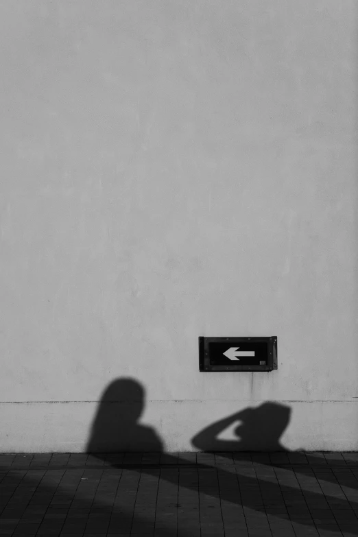 a shadow is cast on the wall by the mailbox