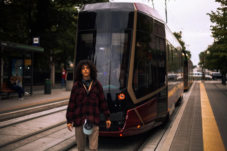 a man stands near the side of a bus