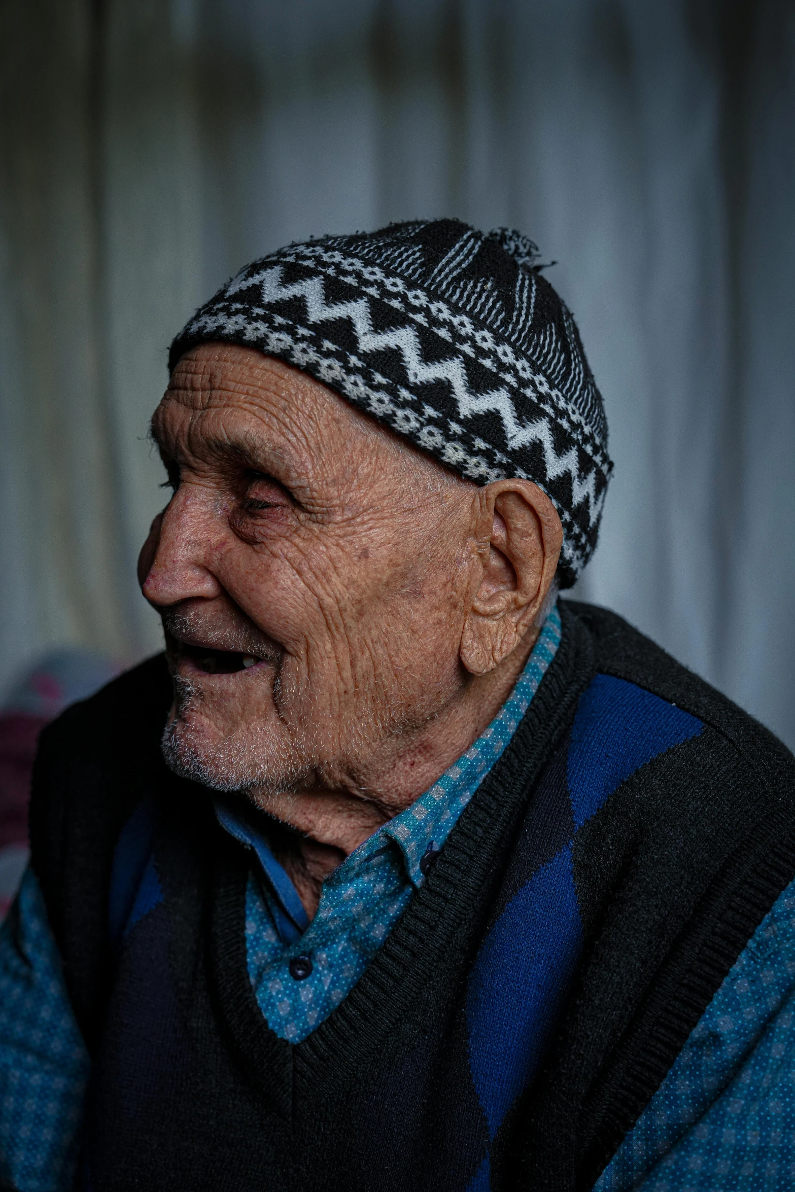 an old man wearing a hat while looking at the camera