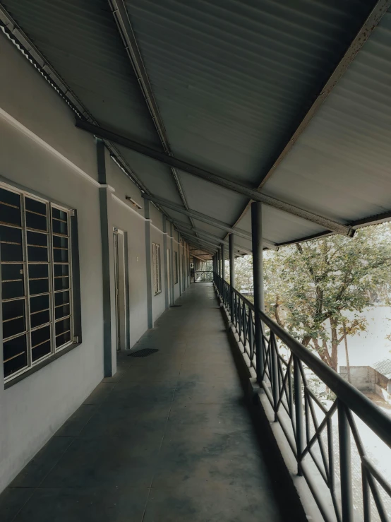 an open porch has lots of windows and black railings