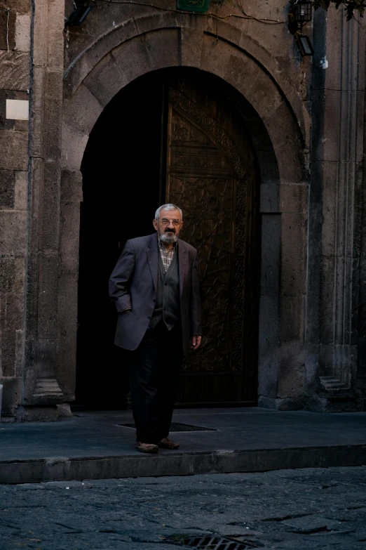 a man standing in an alley way next to an ornate doorway